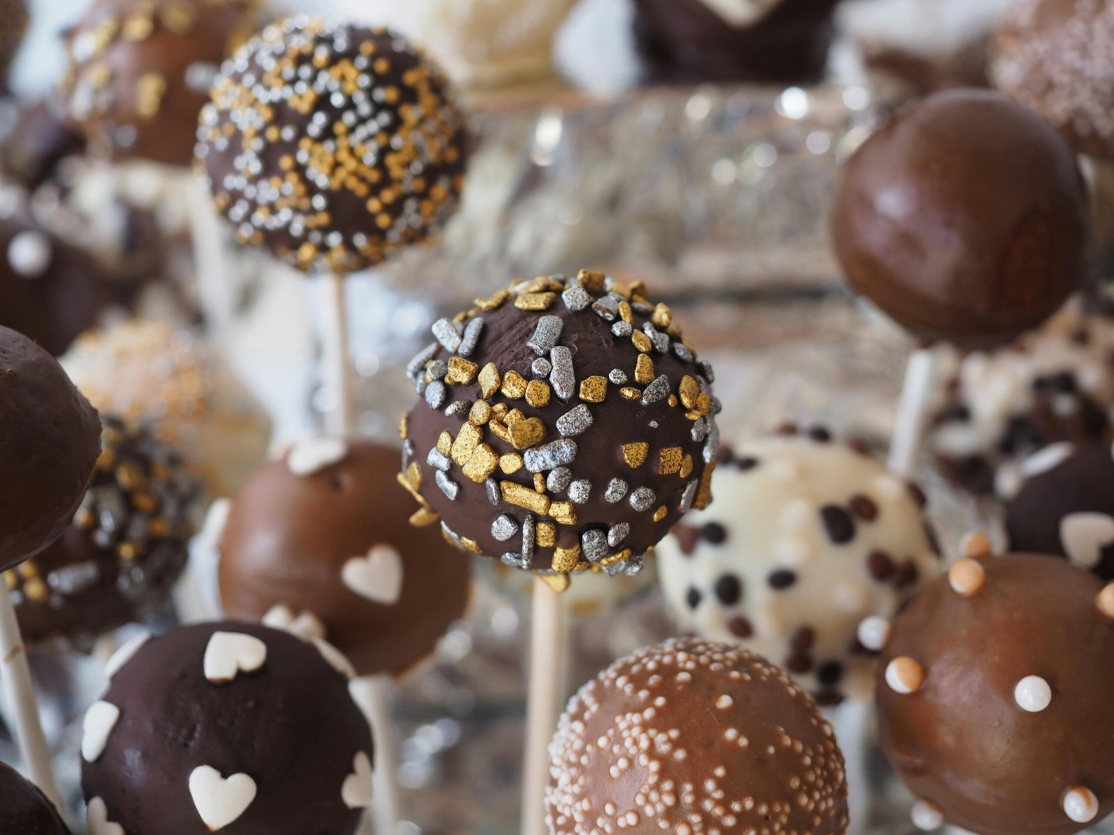 Close-up of assorted cake pops with chocolate and decorative toppings perfect for dessert tables.